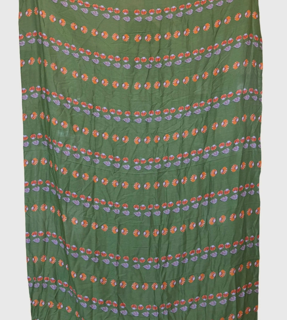 Shell picker on green pareo