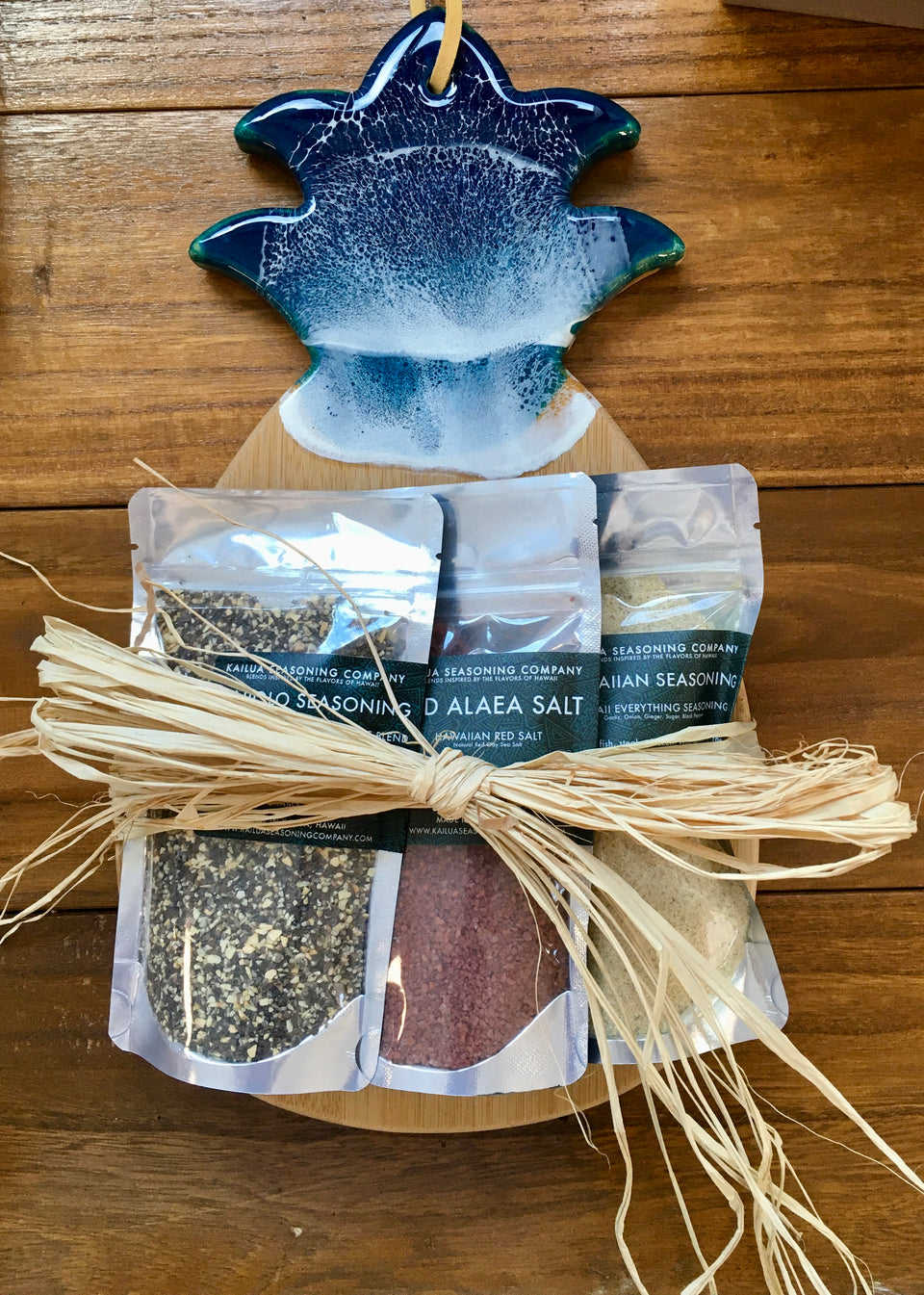 pineapple cutting board with 3 seasoning packets tied on with raffia bow
