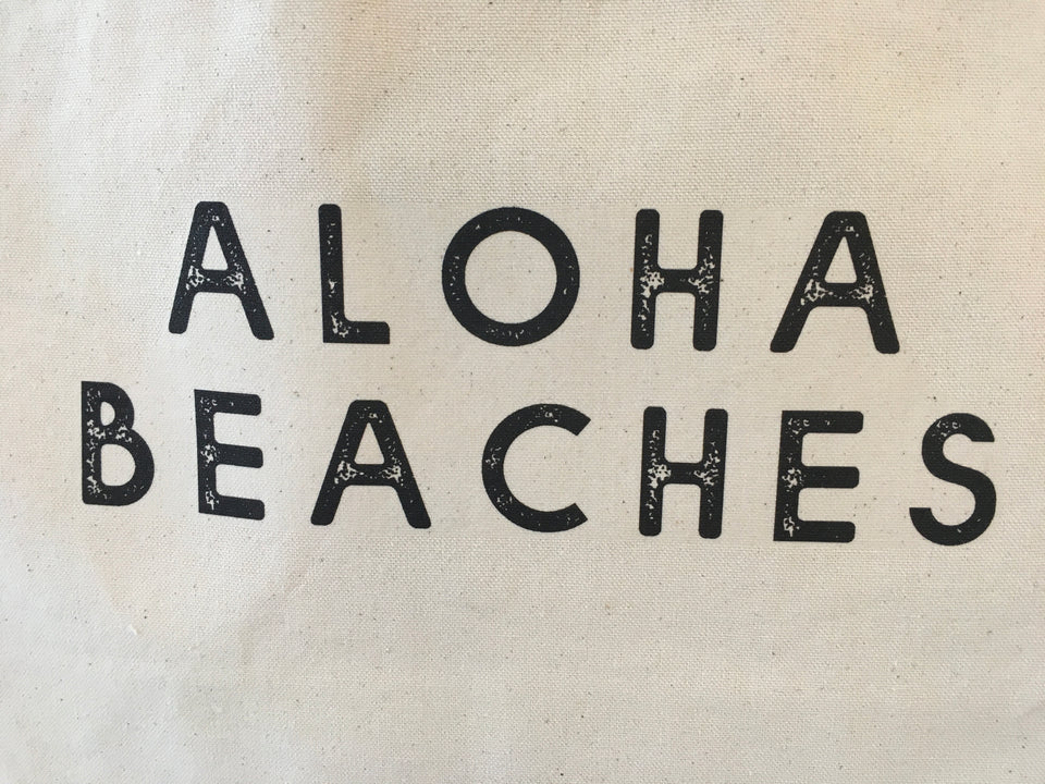 Graphic of Aloha Beaches font on canvas bag.