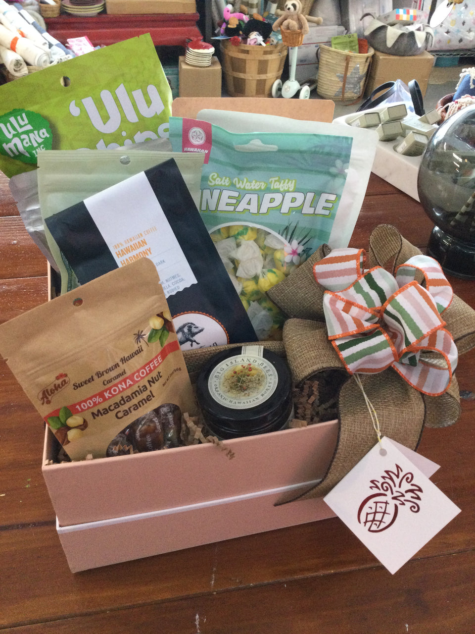 Example of an assortment of local snacks and treats in an open box with ribbon and gift tag 