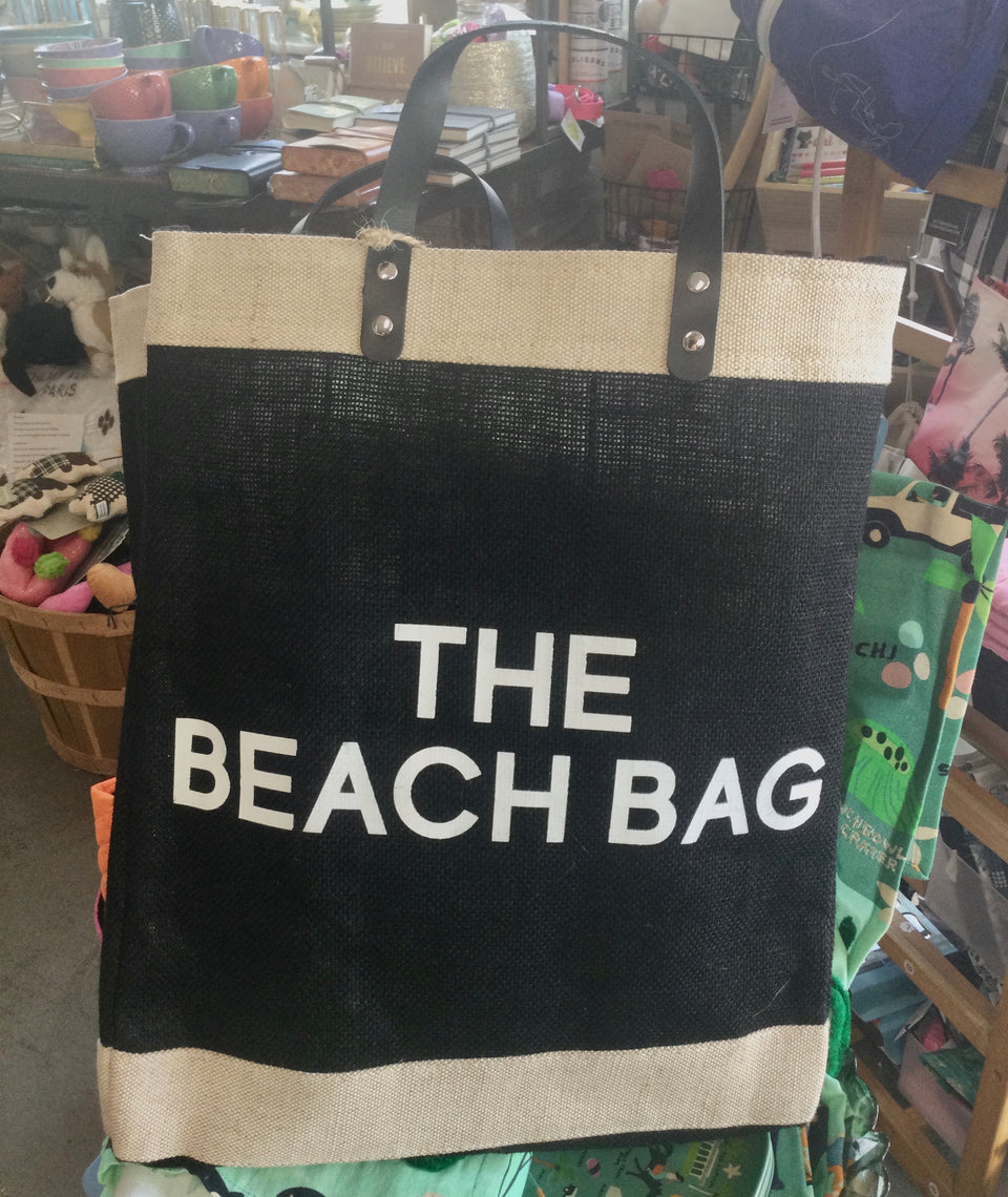 Black just bag with “The beach bag” in white lettering