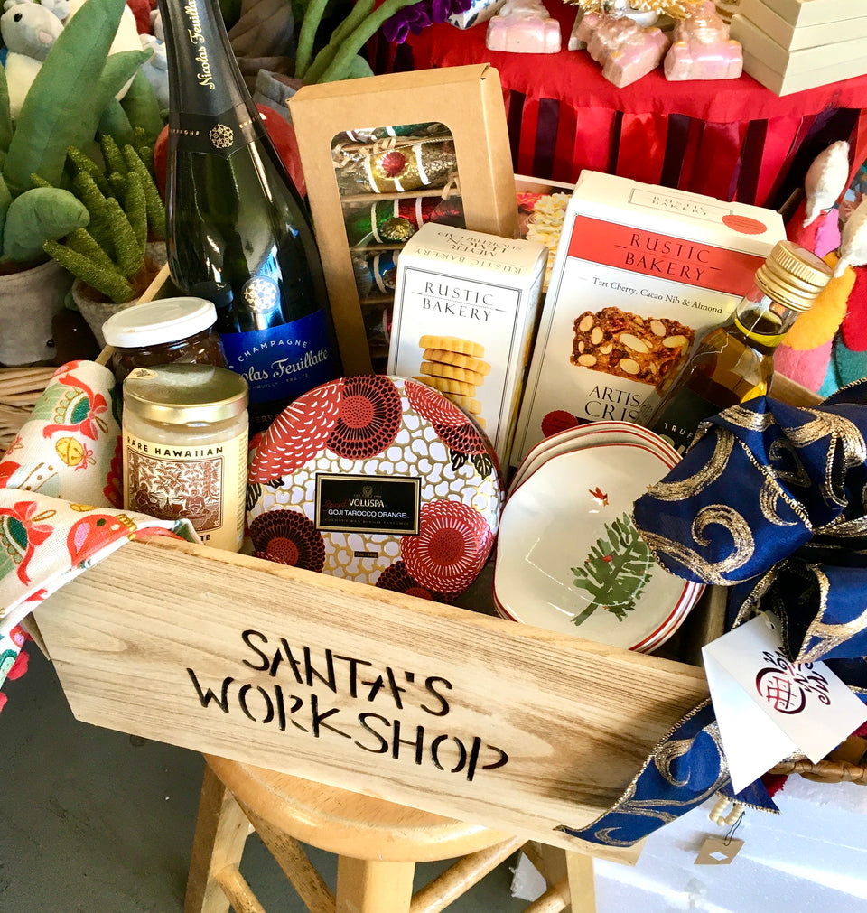 Box crate with honey, fig spread, cookies, crackers, candle, dipping dishes, small set ornaments, truffle oil, a holiday tea towel.