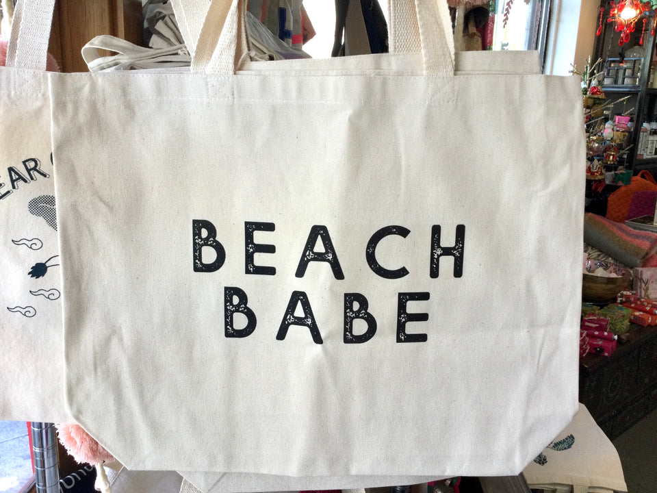 Canvas tote that says “Beach Babe” in black block lettering 