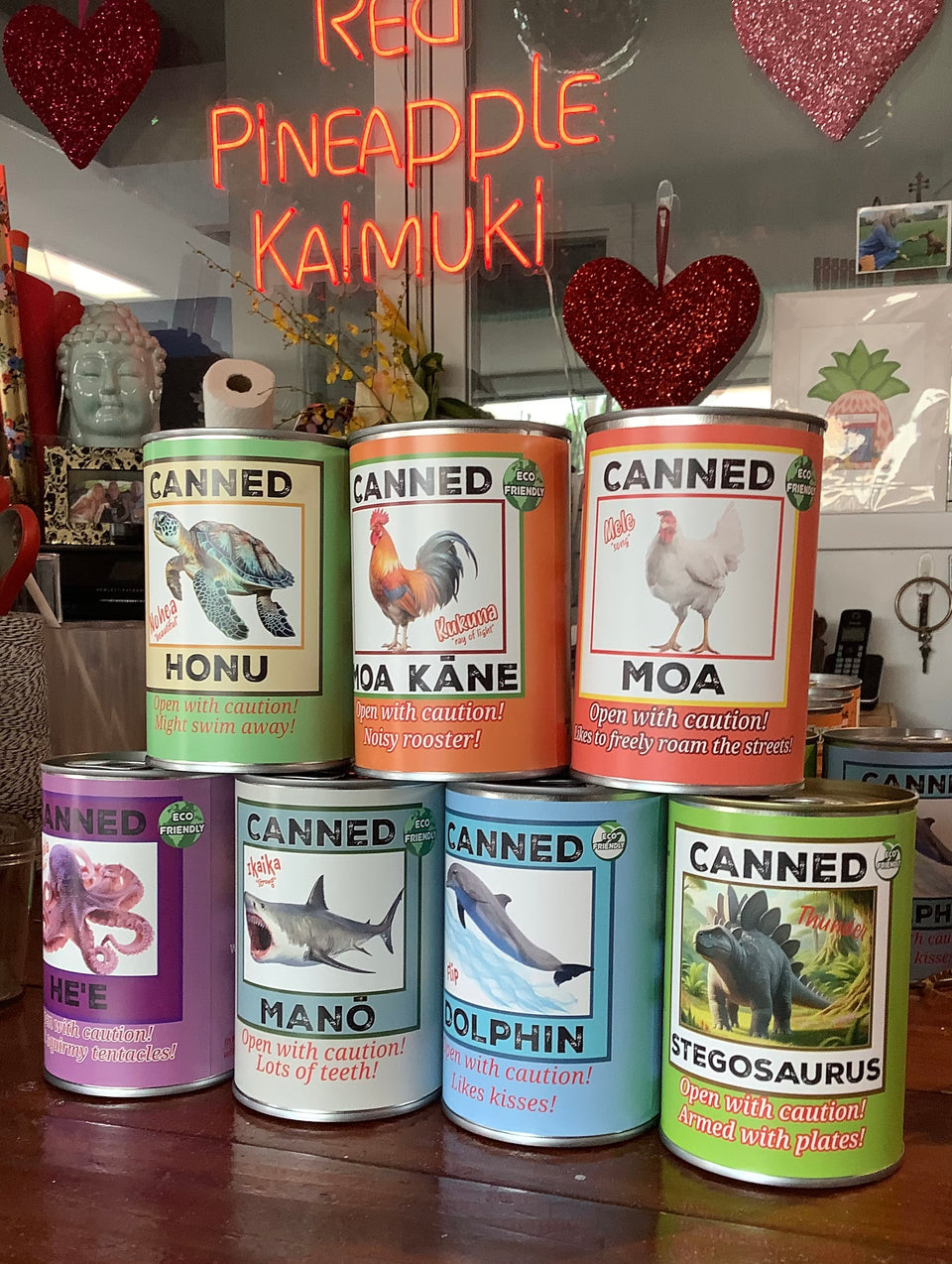 Shows all varieties of canned pets stacks on our desk with our logo in the background.