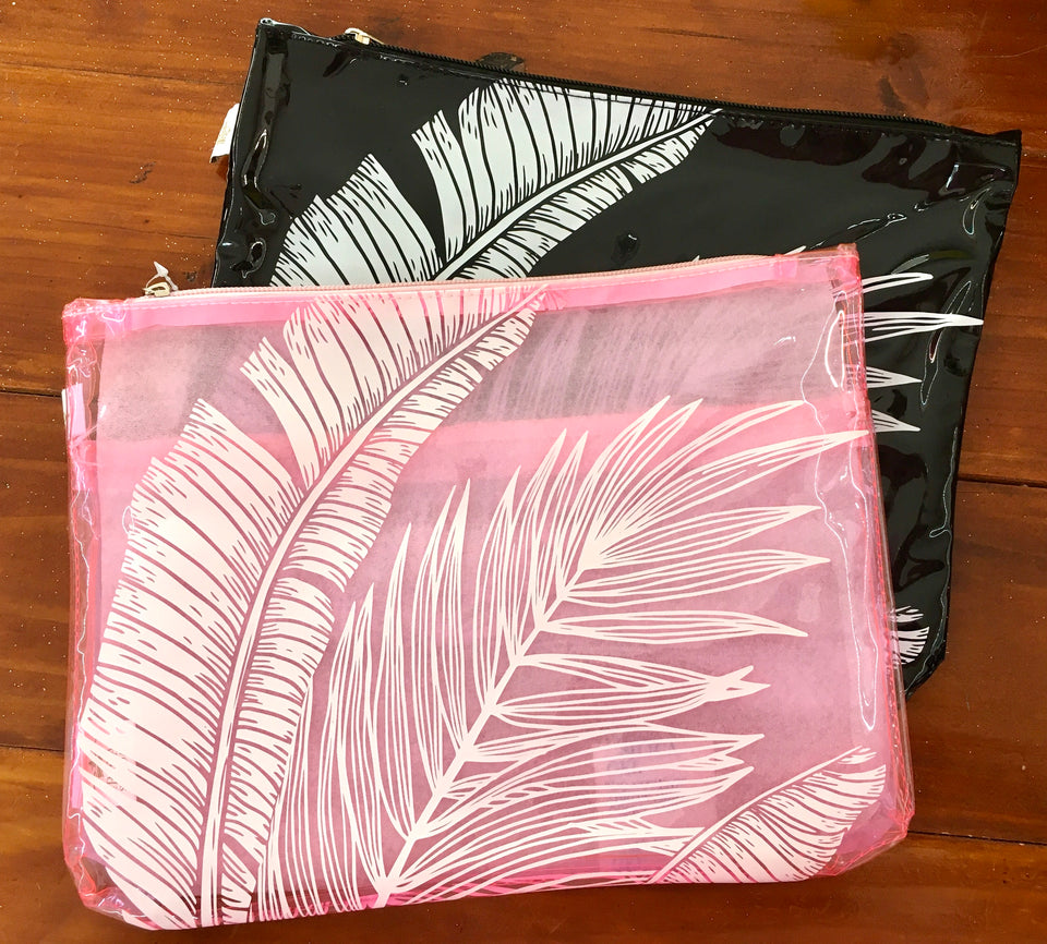 pink and black pouch shown together overlapping on a wooden desk.