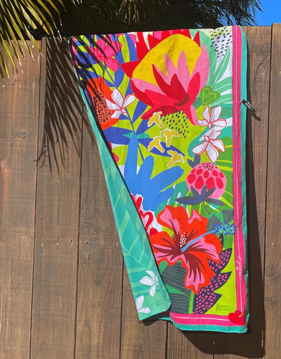 tropical punch towel hung over a wooden fence