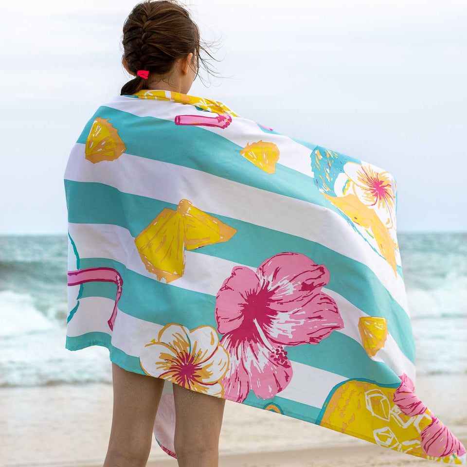 beach towel being used at the beach with ocean in the background