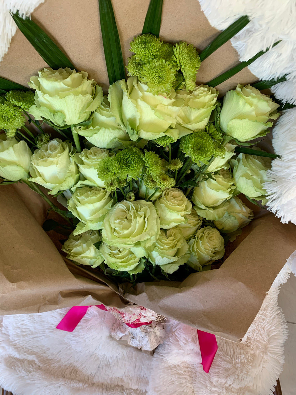 bundle of green roses and leaves wrapped in brown paper
