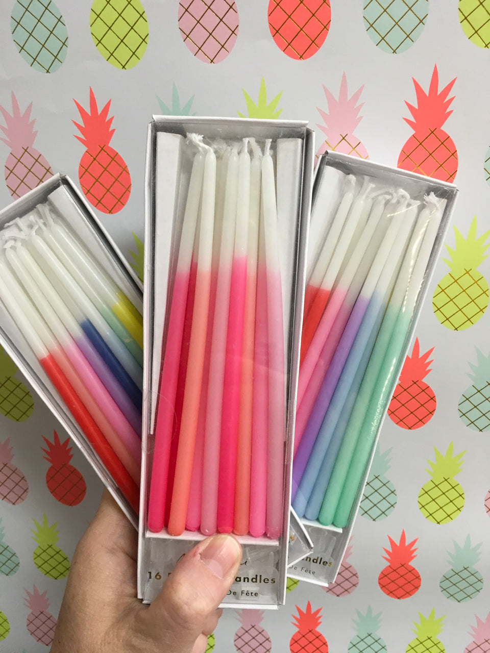 three boxes of multi colored extra long candles